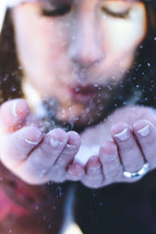 a woman blowing snow 