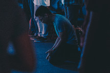 kneeling in prayer and surrender at a worship service 