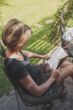 A woman reading outdoors. 