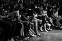 people with heads bowed in prayer during a worship service 