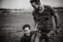 a father and son playing in a field 