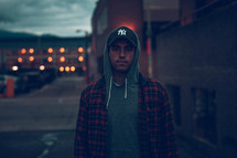 a man in a hoodie standing outdoors 