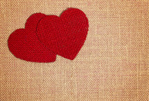 Two Red Burlap Love Hearts on a Brown Burlap Background