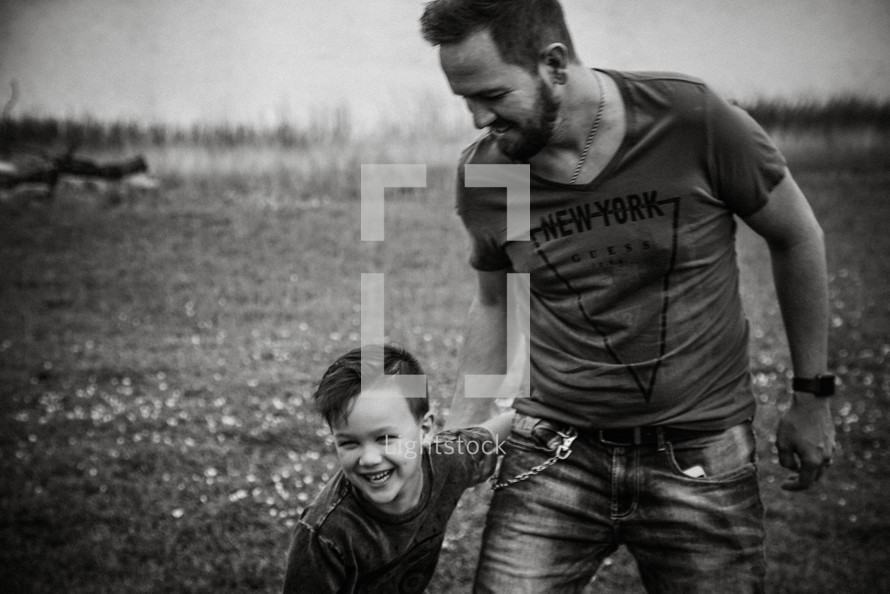 a father and son playing in a field 