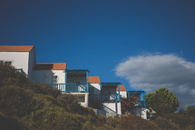 a row of beach houses on a hill 