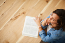 a woman praying and an open Bible 