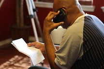 man talking on the phone, paying bills 