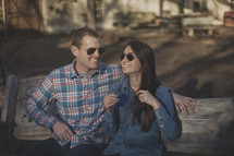 A young couple wearing sunglasses smiling