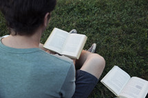 man reading outdoors in the grass 