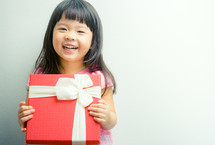 happy girl holding a wrapped gift 