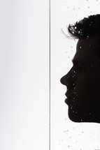 silhouette of a man's face getting wet 