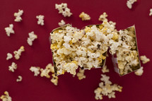 overflowing popcorn boxes on a red background 