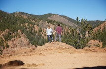 a couple holding hands and view of mountains 