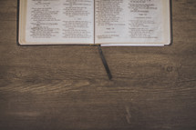 An open Bible and bookmark on wood