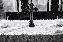 cross and candles on lace runner 