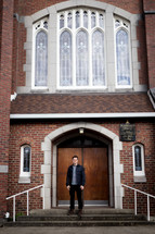 a man standing in front of church doors 