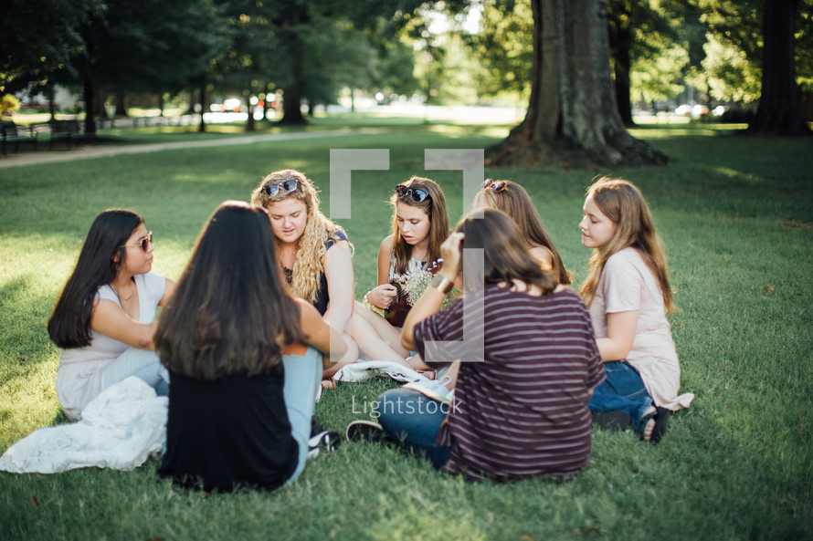 girls sitting in grass talking 