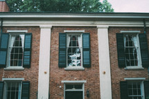 windows and shutters on a brick house 