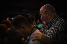 Men praying at a church service.