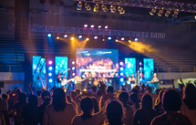 musicians performing on stage in front of a large crowd 
