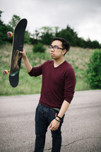 a teen holding a skateboard 