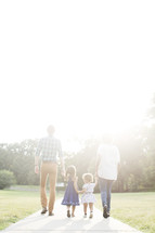 family walking outdoors holding hands 