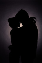 silhouette of a couple in love hugging 