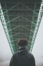 a man standing under a bridge 