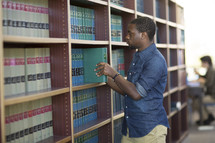 a man looking at books in a library 