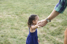 father and daughter holding hands outdoors