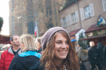 smiling woman standing in a crowded courtyard 