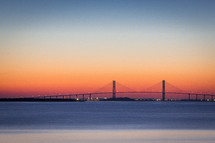 a bridge over a bay at sunset 