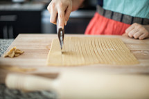 a woman cutting dough 