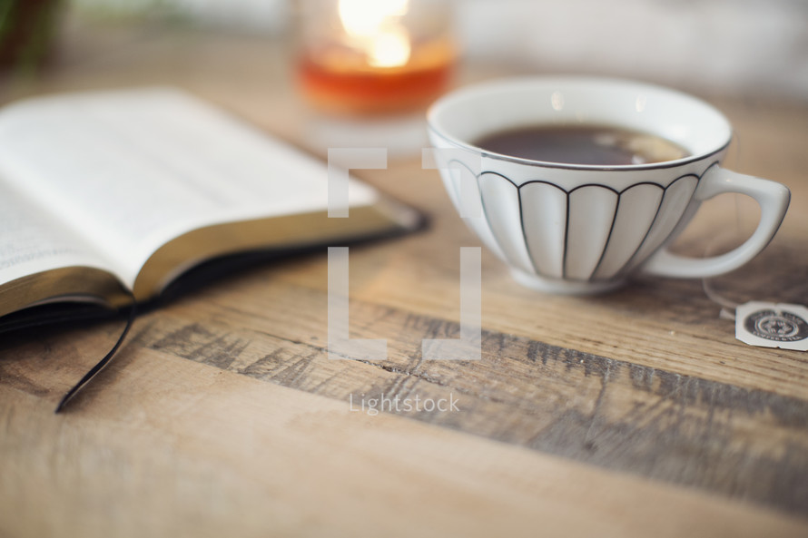 tea, Bible, and candle on a table 