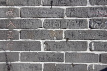 Chinese writing and etchings on brick wall on the great wall of China