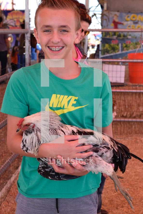 a child holding a chicken at a petting zoo 