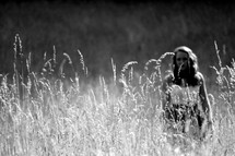 Woman standing in a field of tall grass.
