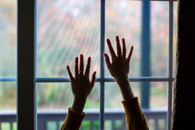 Hands on a window pane.