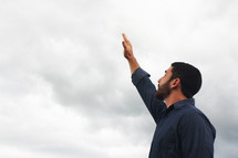 a man with hand raised to God 