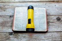 flashlight on the pages of a Bible 