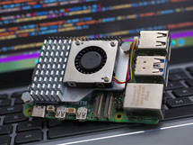 Close-up of a Raspberry Pi 5 on a laptop keyboard. The Raspberry Pi is a credit-card-sized single-board computer developed in the UK