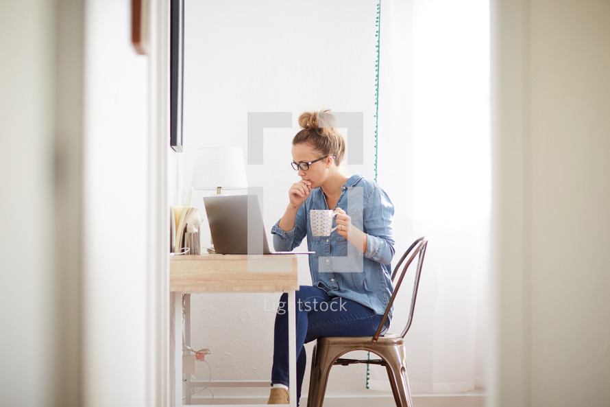a woman sitting in front of a computer at a desk 