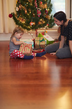 a mother giving her daughter a present to open at Christmas 