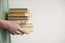 man holding a stack of books 