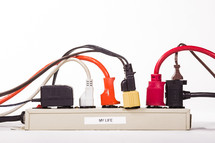 Power strip with labeled plugs depicting a busy life.
