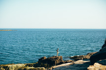 a man standing on a rocky shore 