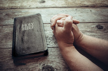 praying hands and a Bible 