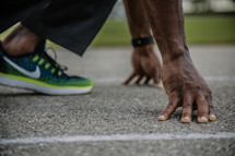 a man in a runner's stance on a track 
