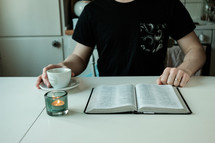 a man with a tea cup and open Bible 