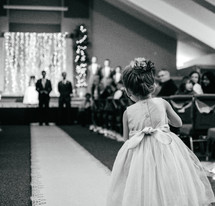 flower girl walking down the wedding aisle 